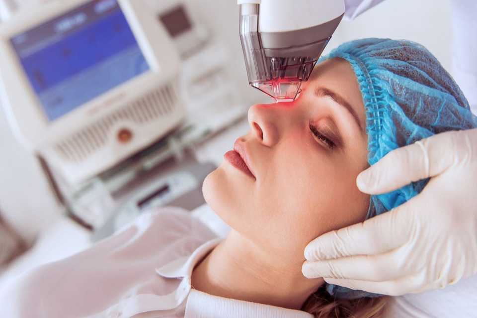 Врач проводит процедуру фракционного лазерного омоложения лица